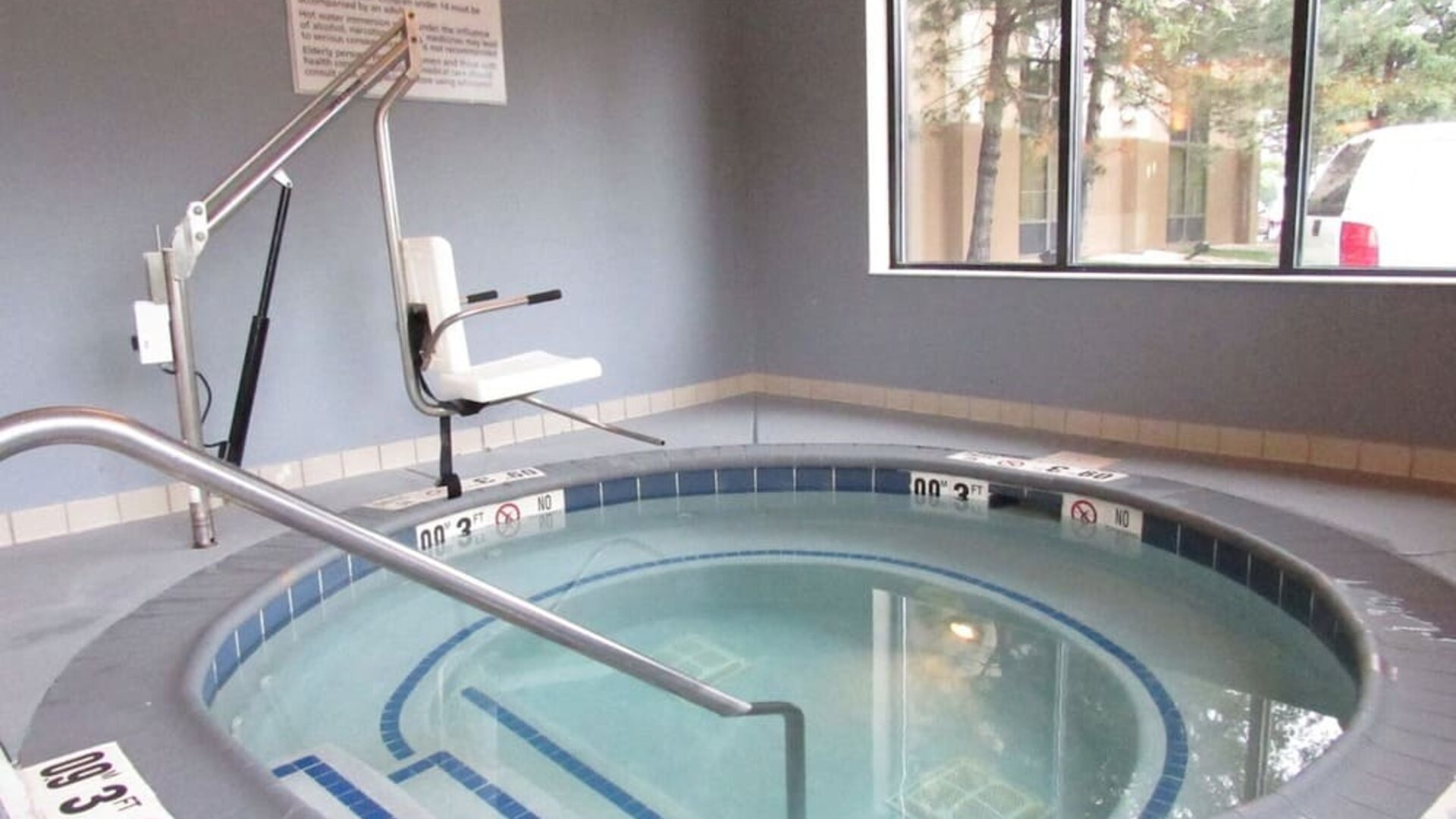 Indoor whirlpool spa featuring accessible lift, handrails and a relaxing space to unwind at Hampton Inn Chicago O'Hare.