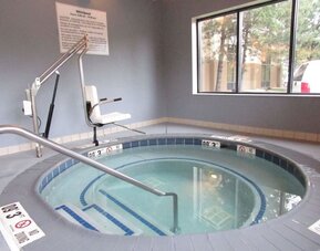 Indoor whirlpool spa featuring accessible lift, handrails and a relaxing space to unwind at Hampton Inn Chicago O'Hare.