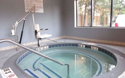 Indoor whirlpool spa featuring accessible lift, handrails and a relaxing space to unwind at Hampton Inn Chicago O'Hare.
