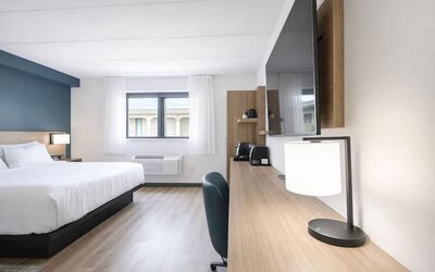 In-room workspace featuring a spacious desk, flat-screen TV, coffee station and comfortable king bed at Hyatt Select Philadelphia Airport.