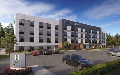 Exterior view of Hyatt Select Philadelphia Airport showcasing the contemporary hotel building, landscaped grounds and guest parking.