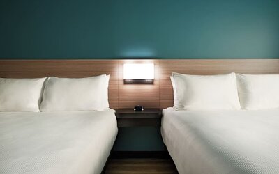 Guest room with two queen beds, modern headboards and comfortable bedding at Hyatt Select Philadelphia Airport.