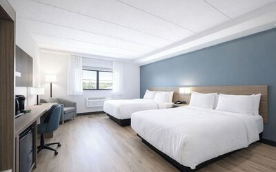 Bright guest room with two queen beds, work desk, mini fridge and coffee maker at Hyatt Select Philadelphia Airport.