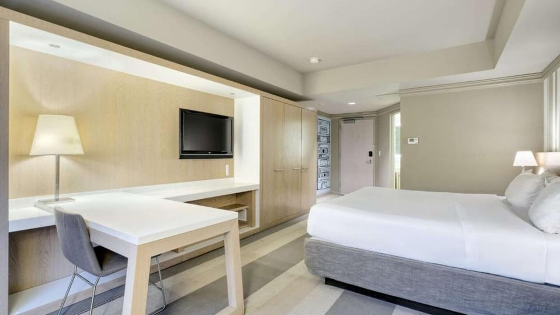 Bright guest room featuring a king bed, large work desk, flat-screen TV and modern furnishings at Royal Sonesta Minneapolis.