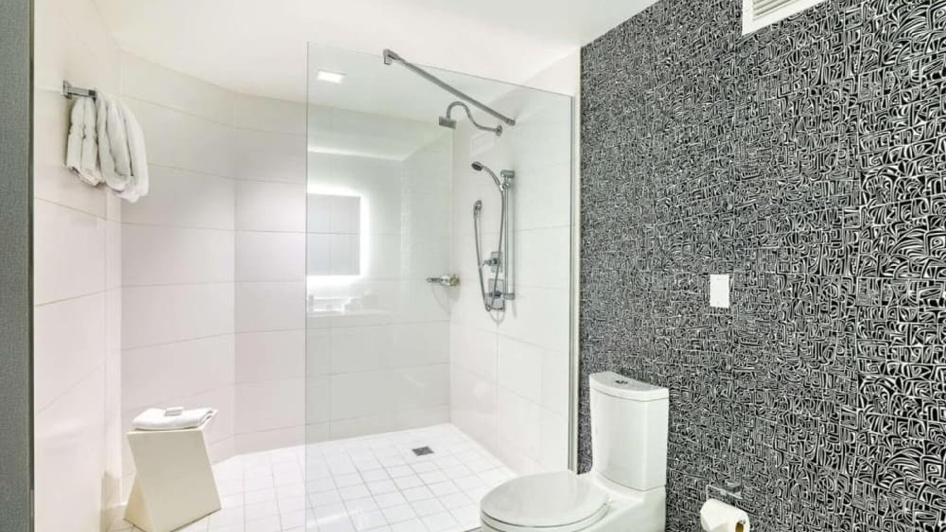 Modern guest bathroom with a spacious walk-in glass shower, contemporary fixtures and illuminated vanity at Royal Sonesta Minneapolis.