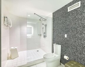 Modern guest bathroom with a spacious walk-in glass shower, contemporary fixtures and illuminated vanity at Royal Sonesta Minneapolis.