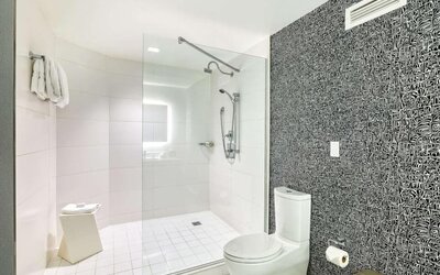 Modern guest bathroom with a spacious walk-in glass shower, contemporary fixtures and illuminated vanity at Royal Sonesta Minneapolis.