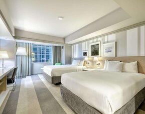 Spacious guest room with two queen beds, modern furnishings and large window at Royal Sonesta Minneapolis.