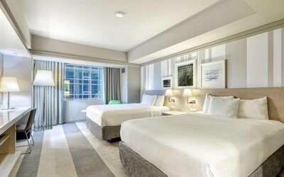 Spacious guest room with two queen beds, modern furnishings and large window at Royal Sonesta Minneapolis.
