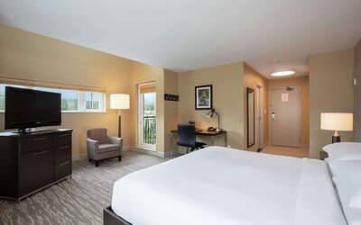 King bed with TV, terrace, workdesk and private bathroom at Hilton Whistler Resort & Spa.