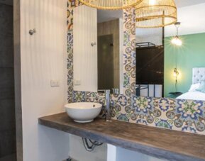 Bathroom at 103 Wonderful House featuring a vessel sink, walk-in shower and colorful patterned tile accents.