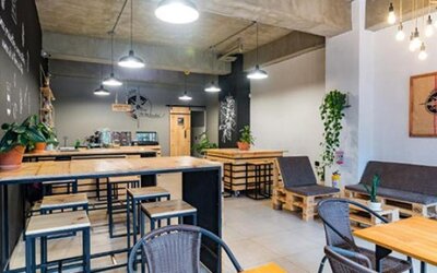 Dining and lounge area at Hotel Loft 32 featuring wooden tables, casual seating, pendant lights and contemporary industrial décor.