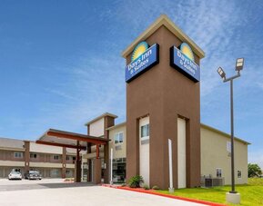 Exterior view of Days Inn & Suites By Wyndham Downtown/University Of Houston featuring the hotel building, entrance and branded signage.