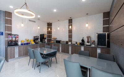 Breakfast and dining area at Days Inn & Suites By Wyndham Downtown/University Of Houston featuring dining tables, beverage stations and breakfast facilities.