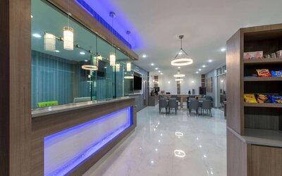 Hotel lobby at Days Inn & Suites By Wyndham Downtown/University Of Houston featuring a modern reception area, dining tables and snack display.