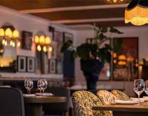 Dining space at Hotel Pulitzer Buenos Aires featuring warmly lit tables, decorative pendant lamps and sophisticated furnishings.
