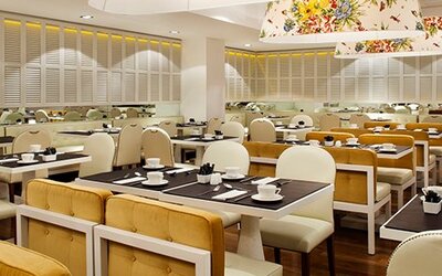 Dining area at Hotel Pulitzer Buenos Aires featuring neatly arranged tables, upholstered seating and contemporary overhead lighting.