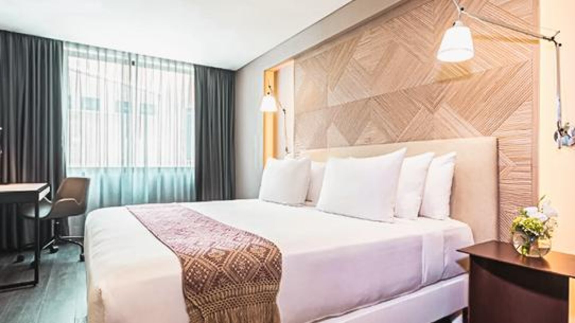 Guest room at NH Collection Mexico City Centro Histórico featuring a large bed, work desk, bedside lighting and contemporary furnishings.