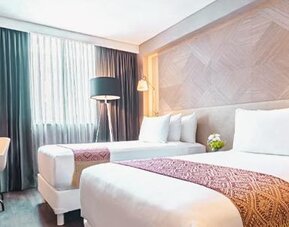 Twin guest room at NH Collection Mexico City Centro Histórico featuring two beds, a work desk, large window and modern wood décor.