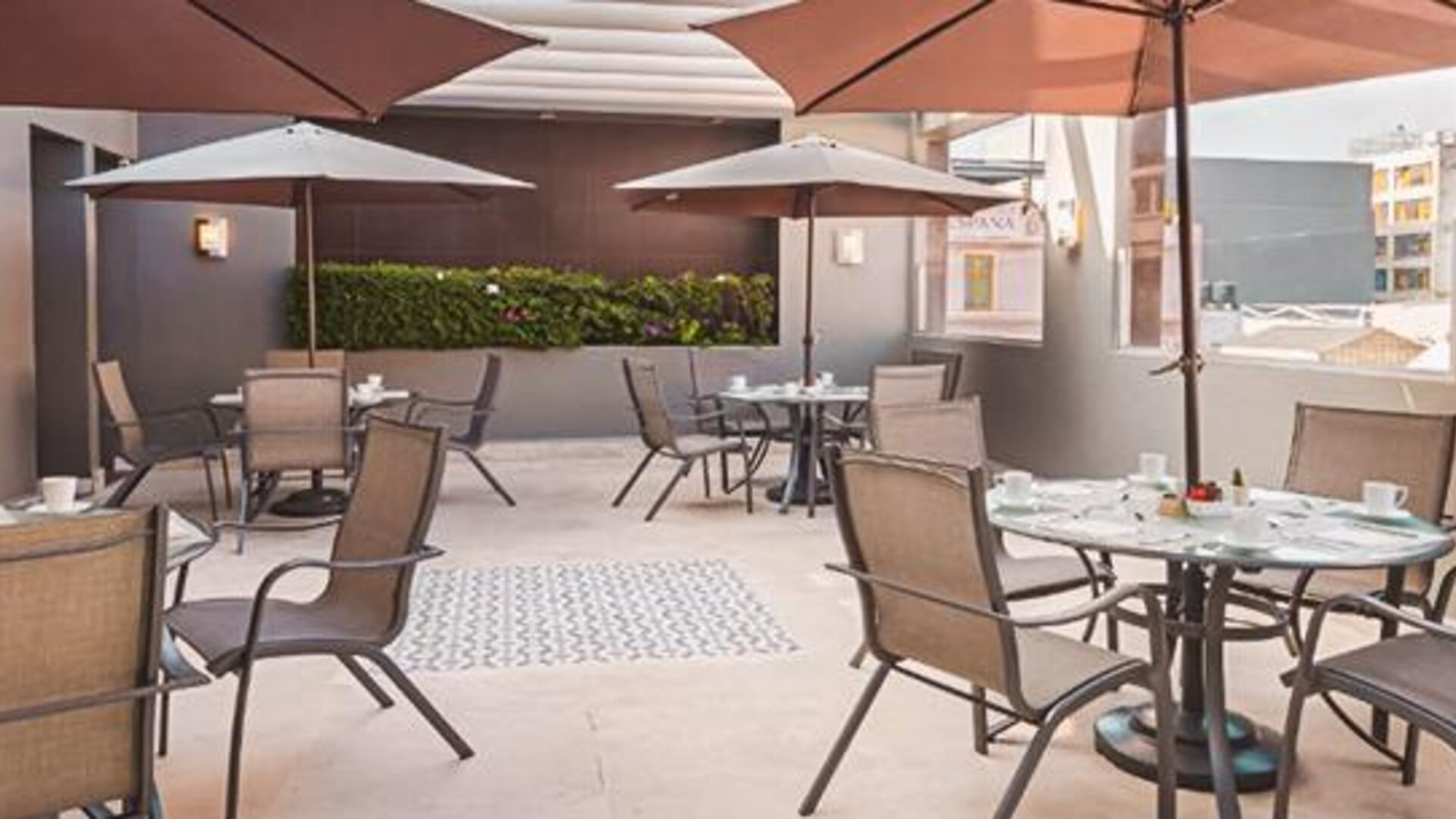 Outdoor dining terrace at NH Collection Mexico City Centro Histórico featuring tables, chairs and large patio umbrellas.