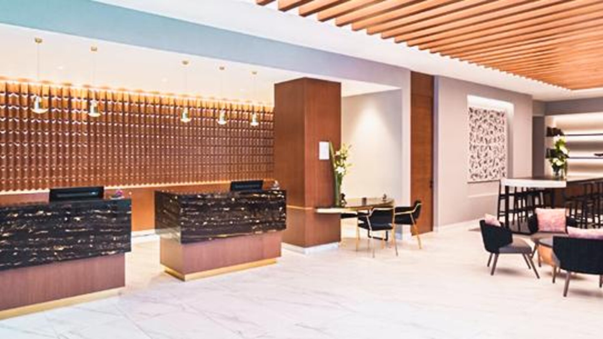 Reception area at NH Collection Mexico City Centro Histórico featuring modern front desks, lounge seating and warm wood accents.