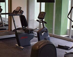 Fitness center at Holiday Inn Lima Airport featuring treadmills, stationary bikes, elliptical machines and mirrored walls.