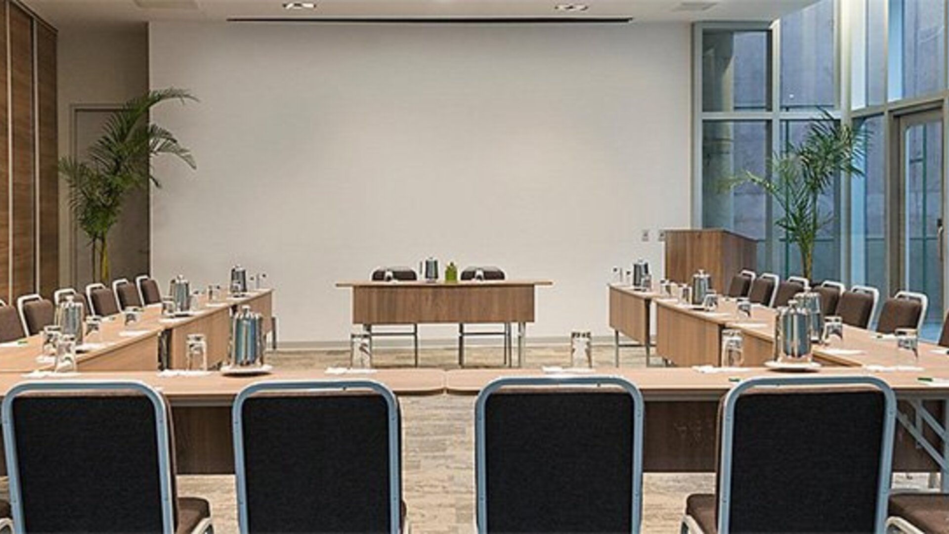 Meeting facility at Holiday Inn Lima Airport featuring U-shaped conference tables, ample seating and presentation space.