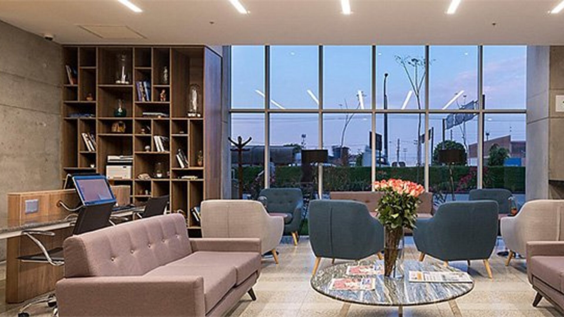 Lobby area at Holiday Inn Lima Airport featuring contemporary sofas, armchairs, bookshelves and floor-to-ceiling windows.
