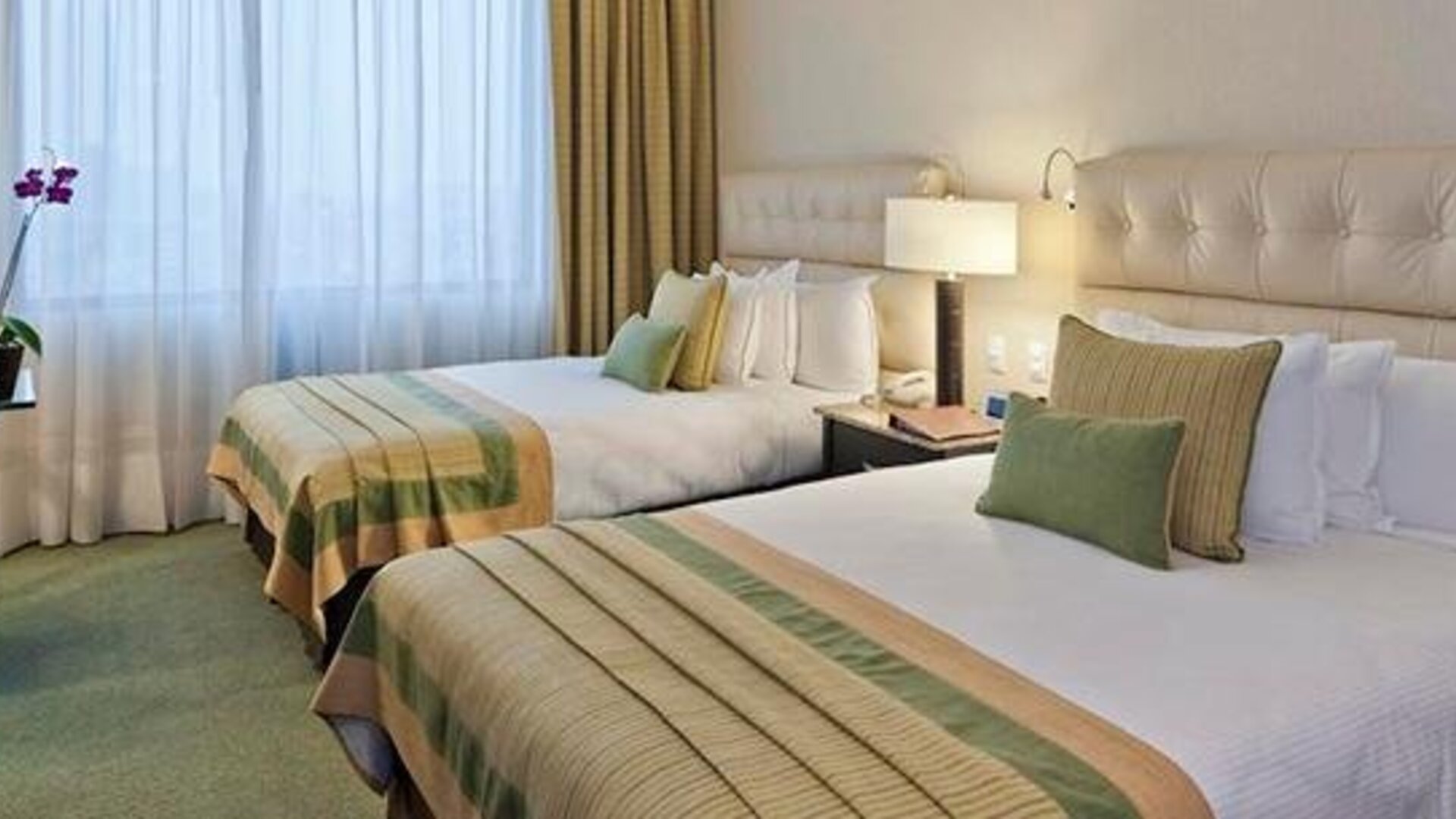 Guest room at Hotel Marquis Reforma featuring two beds, upholstered headboards, bedside lighting and contemporary décor.