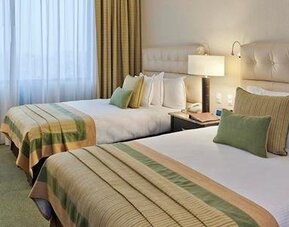 Guest room at Hotel Marquis Reforma featuring two beds, upholstered headboards, bedside lighting and contemporary décor.