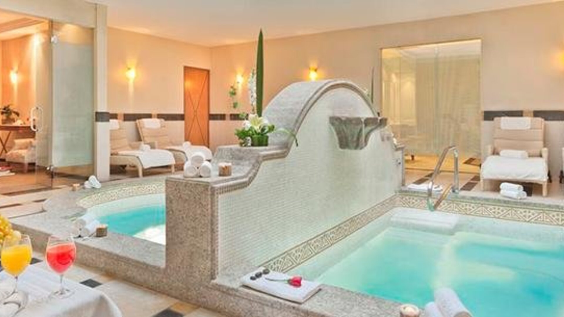Spa area at Hotel Marquis Reforma featuring two whirlpool tubs, lounge chairs and a bright relaxation space.