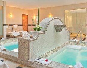 Spa area at Hotel Marquis Reforma featuring two whirlpool tubs, lounge chairs and a bright relaxation space.