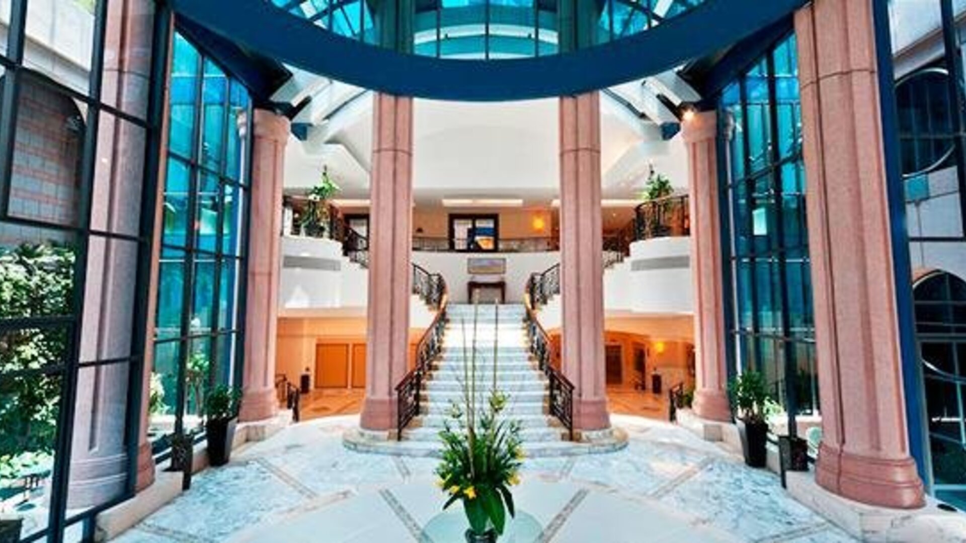 Elegant lobby at Hotel Marquis Reforma featuring blue tufted sofas, large round mirrors and modern seating.