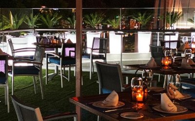Outdoor dining terrace at Hotel Marquis Reforma featuring set tables, contemporary seating and ambient evening lighting.