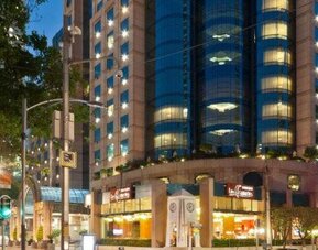 Evening exterior view of Hotel Marquis Reforma with the illuminated hotel façade along the city street.