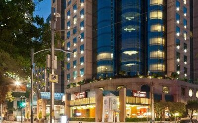 Evening exterior view of Hotel Marquis Reforma with the illuminated hotel façade along the city street.