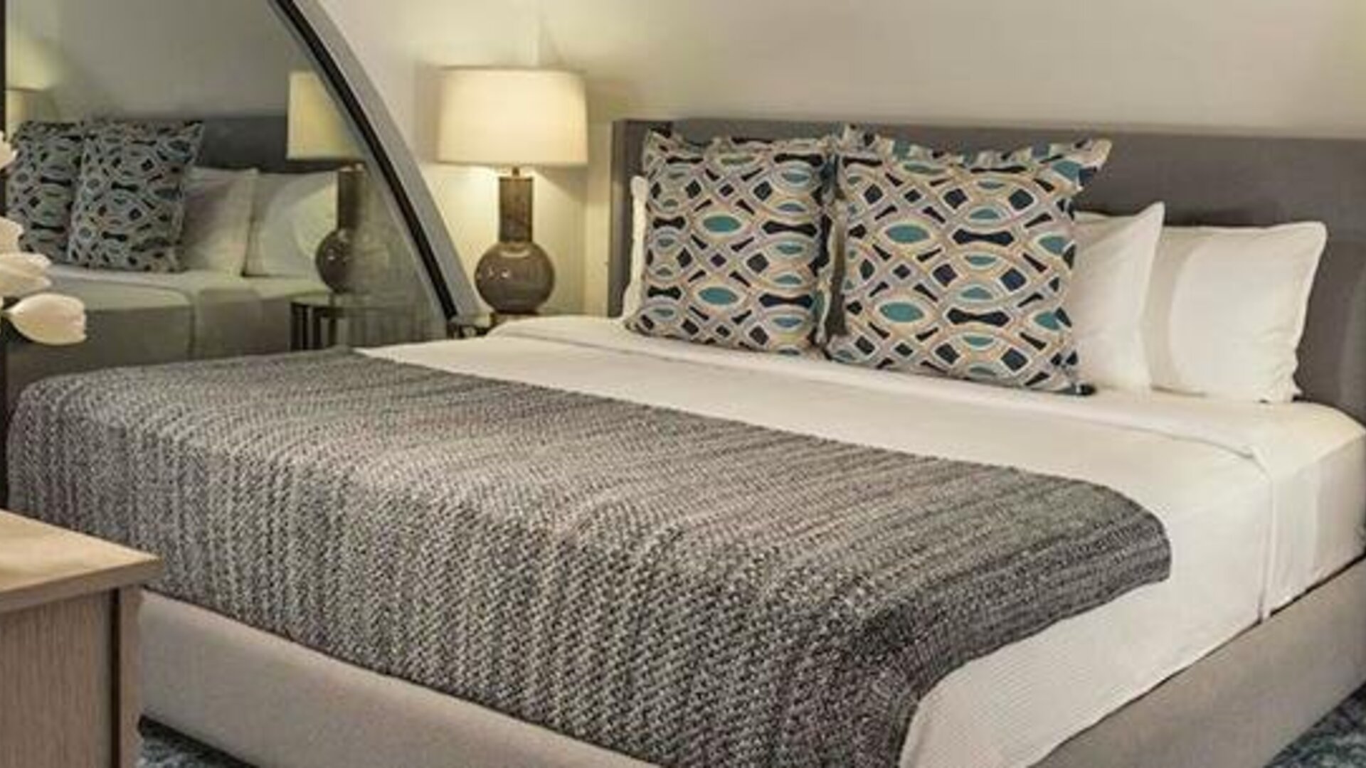 Guest room at Hotel Marquis Reforma featuring a king bed, patterned cushions, bedside lamps and contemporary furnishings.