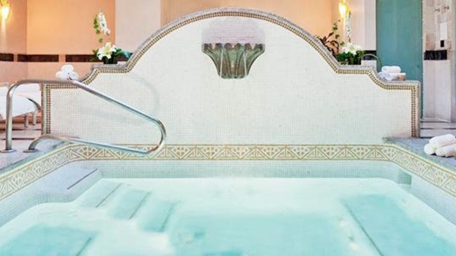 Spa whirlpool at Hotel Marquis Reforma featuring tiled surrounds, handrails and lounge chairs.