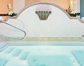 Spa whirlpool at Hotel Marquis Reforma featuring tiled surrounds, handrails and lounge chairs.