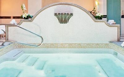 Spa whirlpool at Hotel Marquis Reforma featuring tiled surrounds, handrails and lounge chairs.