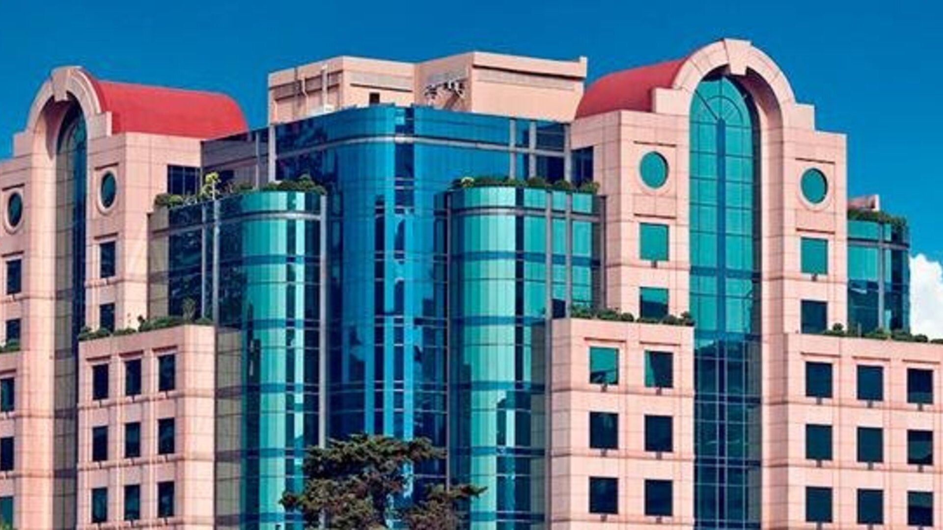 Daytime exterior of Hotel Marquis Reforma featuring its distinctive glass and stone façade.