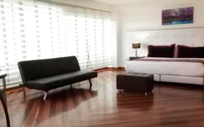 Bright guest room featuring a king bed, large window, city views and contemporary furnishings at Hotel Airport Travel.