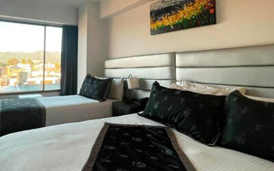 Bright guest room featuring two beds, large windows and city views at Hotel Airport Travel.