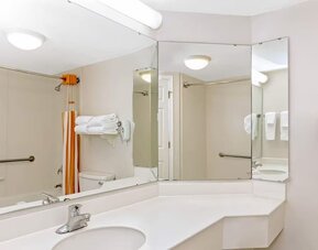Accessible bathroom featuring a large vanity, safety grab bars and a shower and bathtub combination at La Quinta Inn & Suites By Wyndham Orlando I Drive/Conv Ctr.