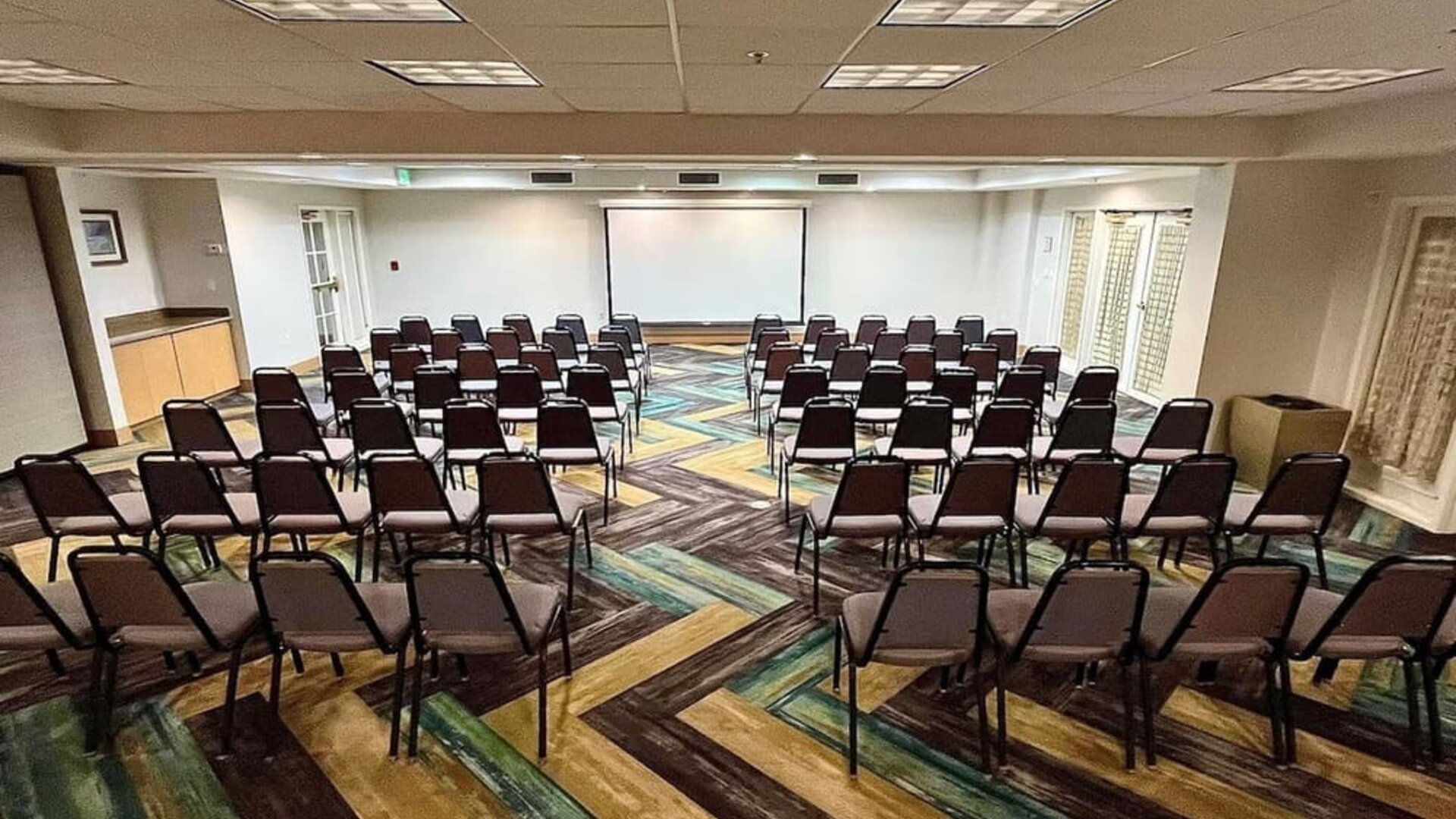 Meeting room featuring theater-style seating, presentation facilities and flexible event space at La Quinta Inn & Suites By Wyndham Orlando I Drive/Conv Ctr.