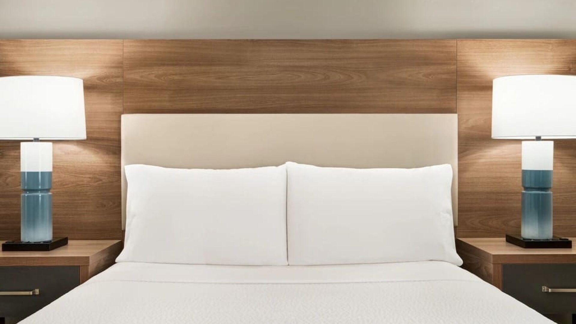 Comfortable guest room featuring a plush bed, wood-accented furnishings and bedside lighting at Candlewood Suites Meridian.