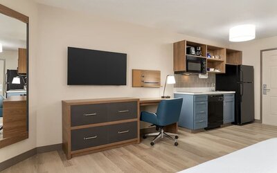 In-room workspace and kitchenette featuring a full-size refrigerator, microwave, dishwasher and dedicated desk area at Candlewood Suites Meridian.