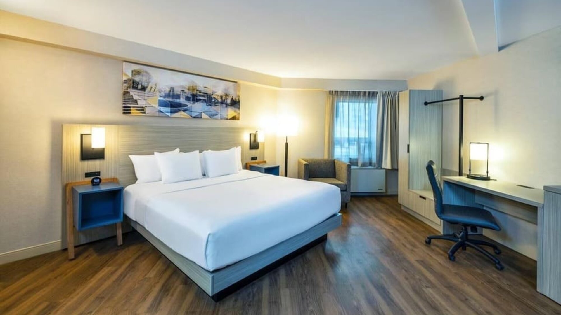 Spacious king room featuring wood-style flooring, a dedicated workspace and comfortable furnishings at Comfort Inn Truro.
