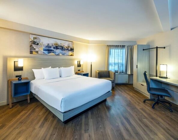 Spacious king room featuring wood-style flooring, a dedicated workspace and comfortable furnishings at Comfort Inn Truro.