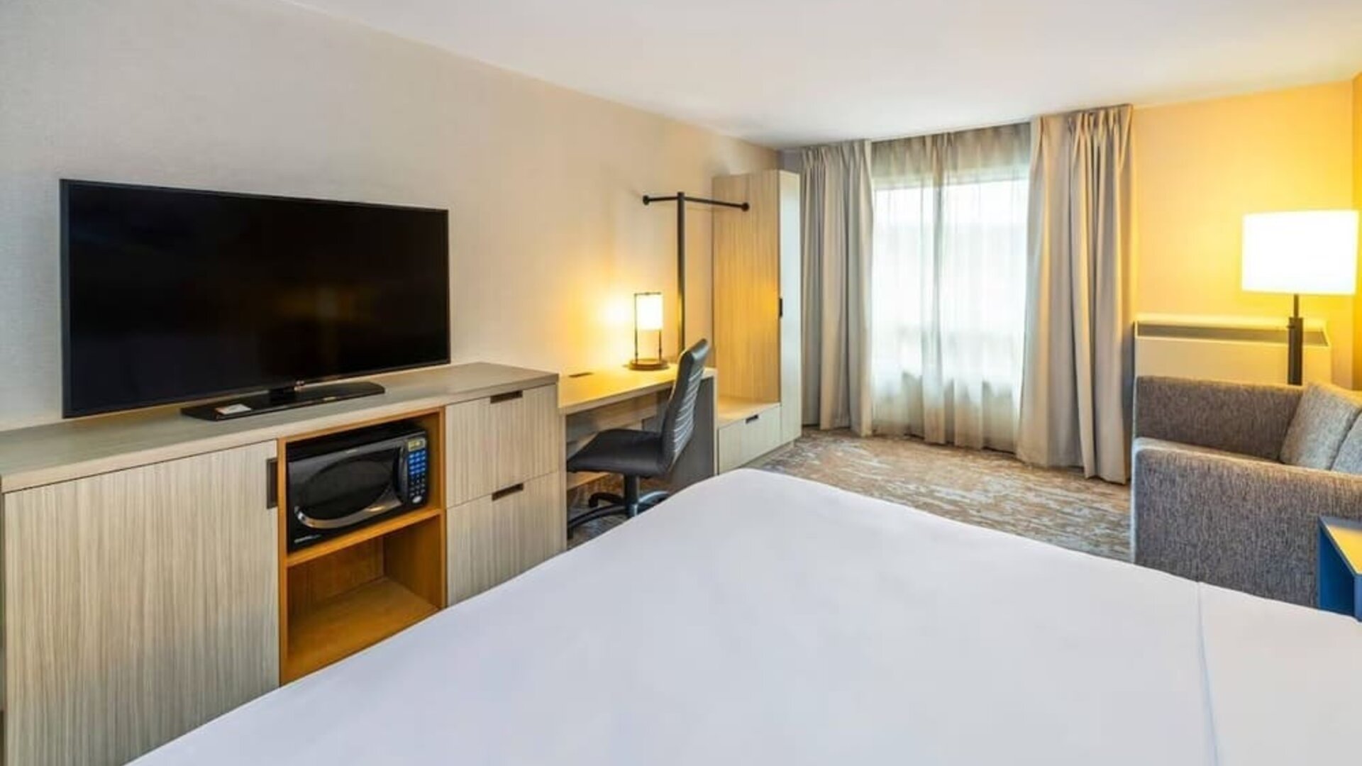 Guest room featuring an in-room workspace, a microwave, a flat-screen television and comfortable seating at Comfort Inn Truro.